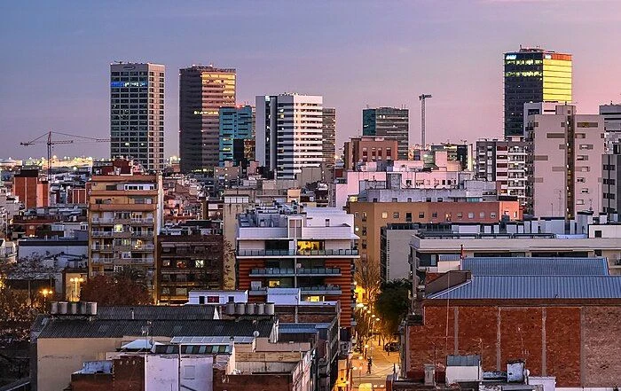 EQUIPO DE MUDANZAS LA SEDA CARGANDO MUEBLES EN UNA CALLE DE L'HOSPITALET DE LLOBREGAT CON CAMIÓN MARCADO